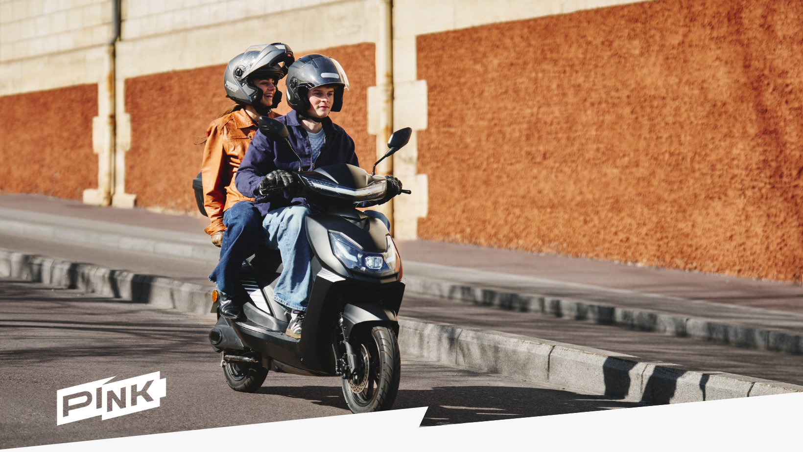 L'image représente un start avec deux jeunes dessus, conduisant en ville.